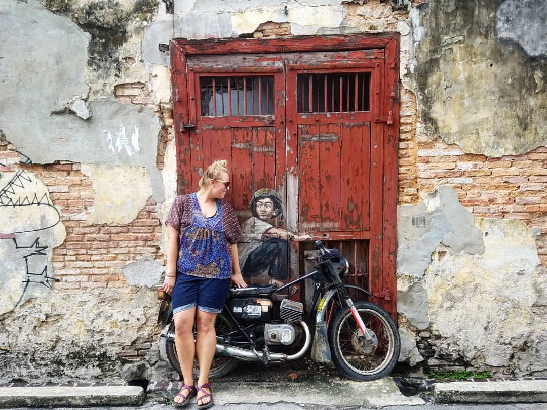 Sienna smiling at motorcycle statue on the street